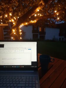 Ein Laptop unter einem Baum mit Lichterkette abends im B.I.E.K. Seminarhaus in Süddeutschland